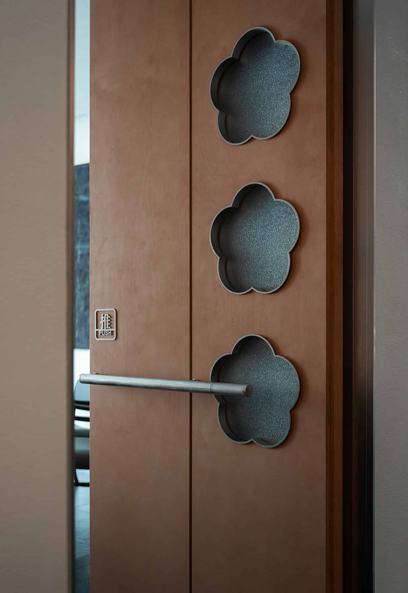 Yang’s Qing Lobster · Bai Jia Hu Store Door Handle Detail by IN.X Yang’s Qing Lobster · Bai Jia Hu Store by IN.X — brushed metal door handle through cloud cutout, Nanjing, China