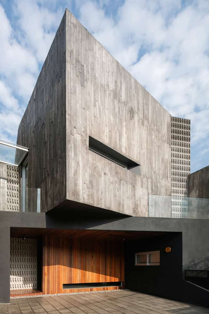 10º House by STUDIE, cantilevered concrete volume above entry in Jakarta, Indonesia