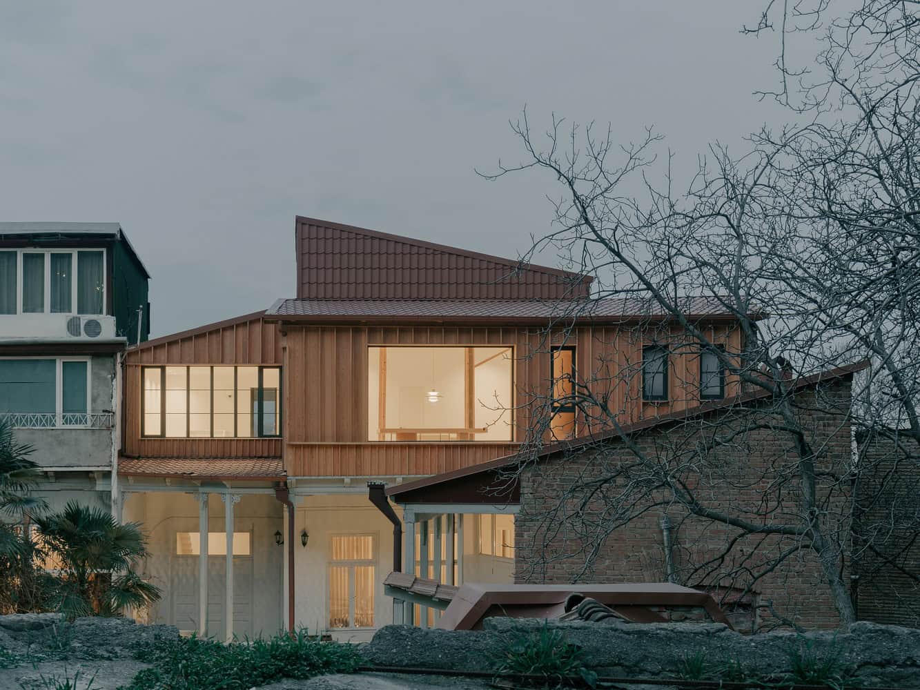 Modern residential house with contemporary design, large windows, and unique roof structure showcasing innovative architecture and home interior concepts.