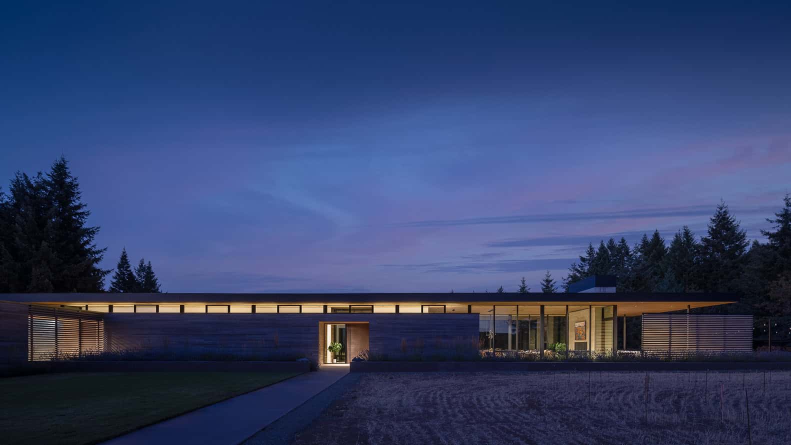 Evening Sky Residence by Scott I Edwards Architecture, front elevation glowing at night in McMinnville, Oregon, USA