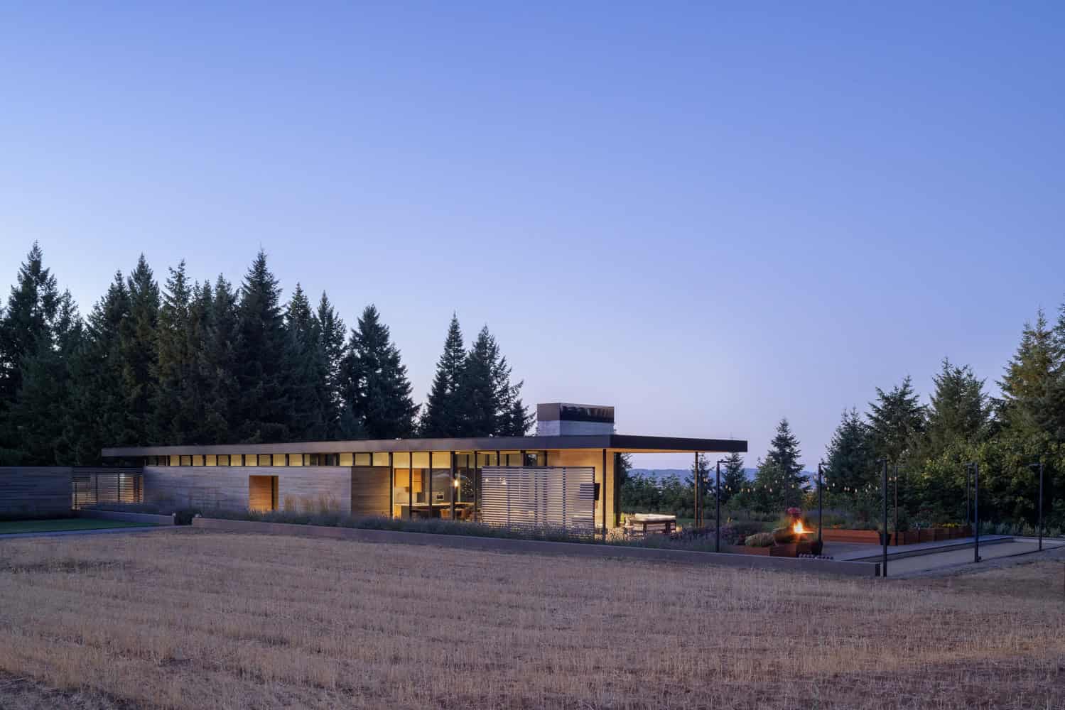 Evening Sky Residence by Scott I Edwards Architecture, side elevation in the landscape at dusk in McMinnville, Oregon, USA