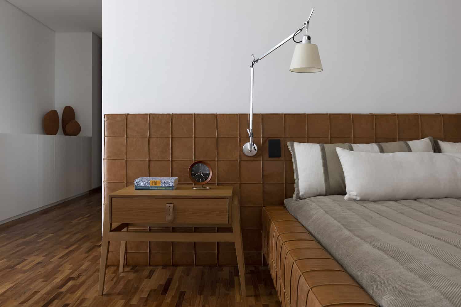 Bedroom detail with leather headboard at FE House designed by N2B Arquitetura
