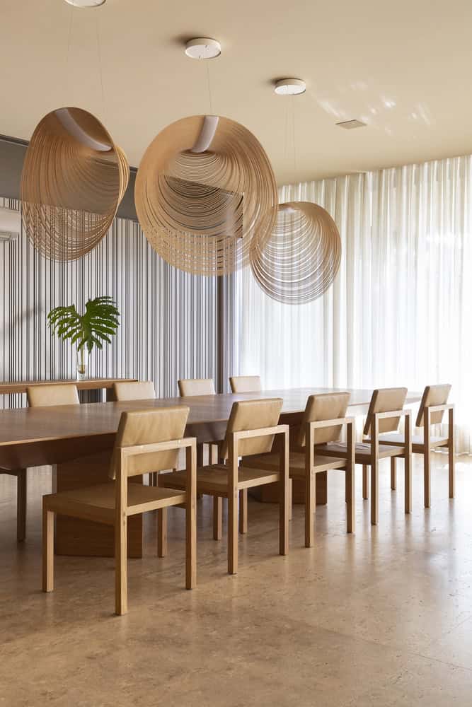 Dining room with sculptural pendant lights at FE House by N2B Arquitetura