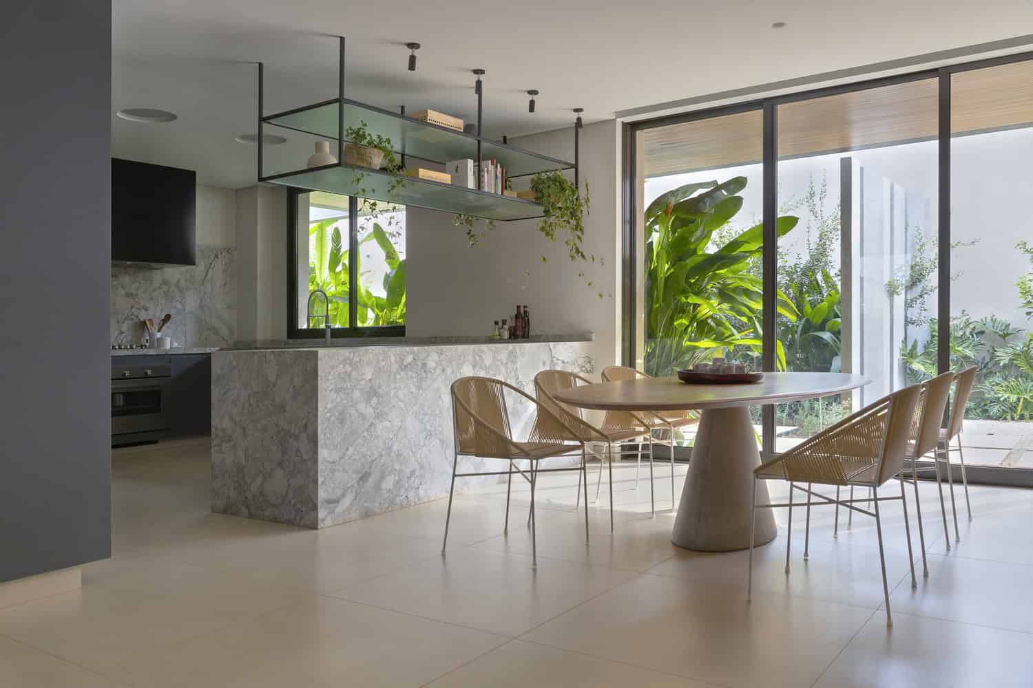 Kitchen dining area with garden views at FE House by N2B Arquitetura