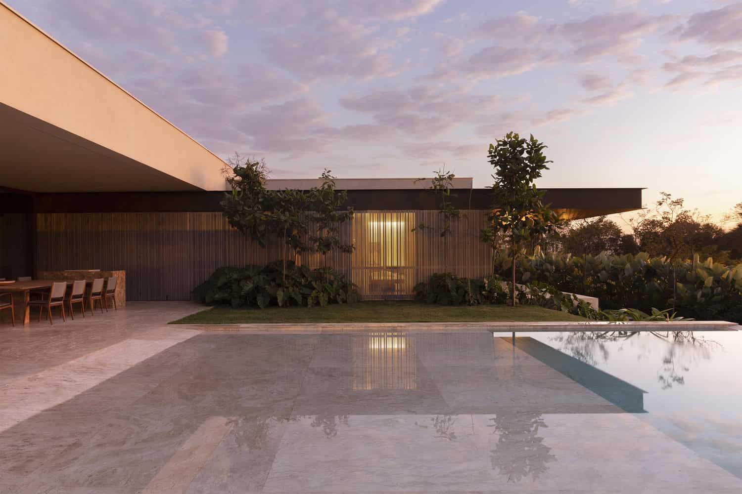 Pool and terrace at night at FE House by N2B Arquitetura