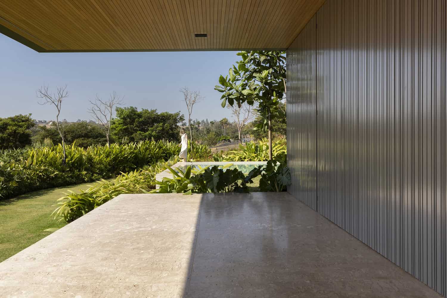 FE House by N2B Arquitetura covered terrace overlooking the garden in Ribeirão Preto, Brazil