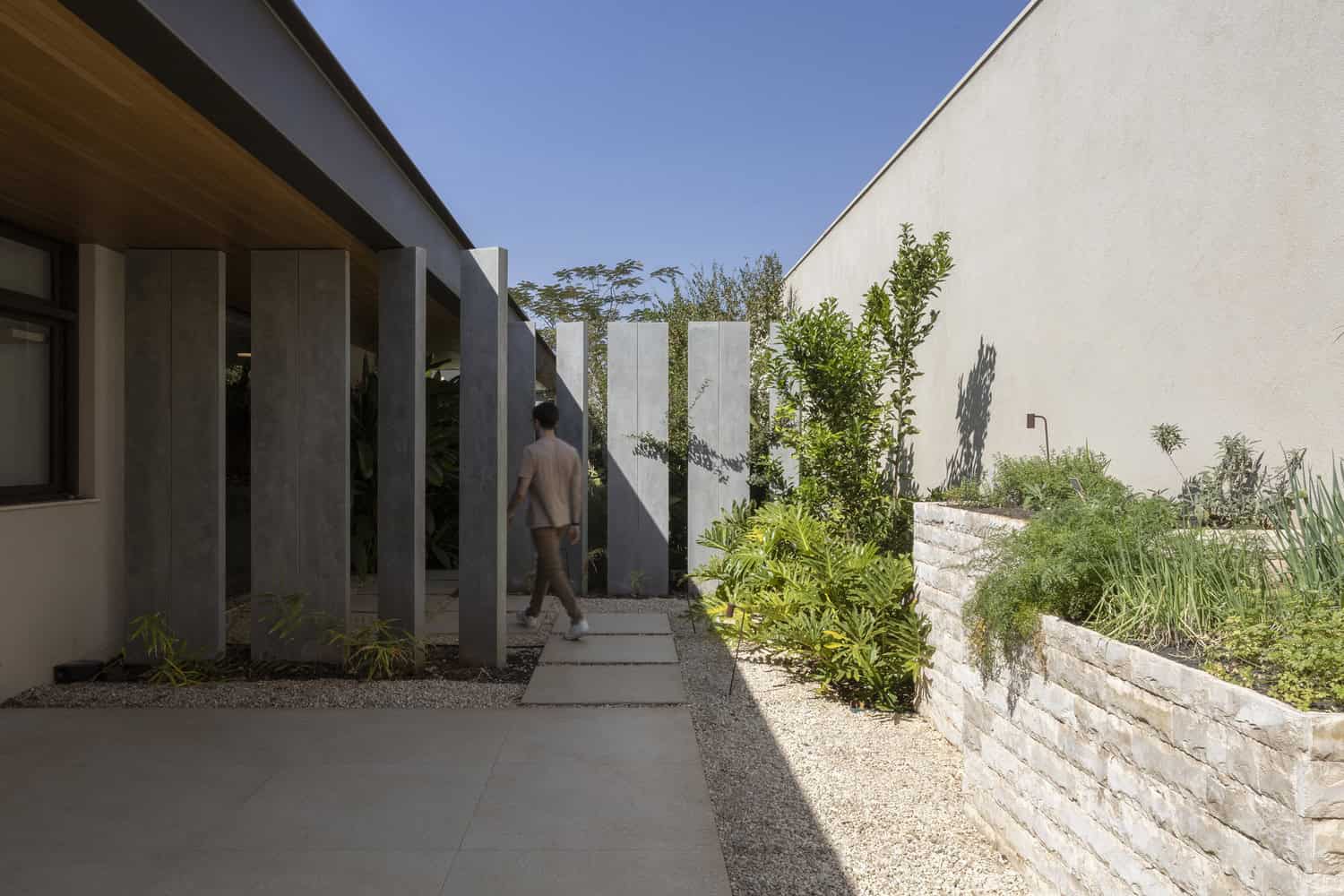 FE House by N2B Arquitetura entry courtyard with vertical concrete fins in Ribeirão Preto, Brazil