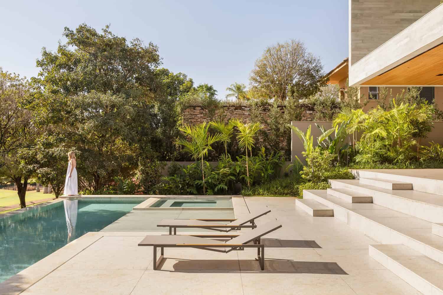 Pool and garden edge at House AL by N2B Arquitetura in Vila do Golfe, Brazil