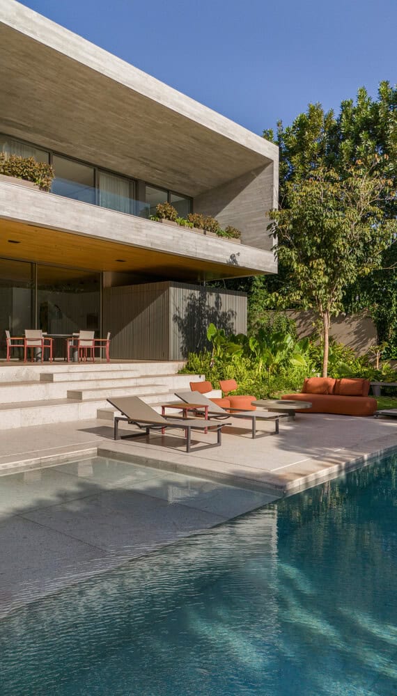 Pool terrace with loungers at House AL by N2B Arquitetura in Vila do Golfe, Brazil