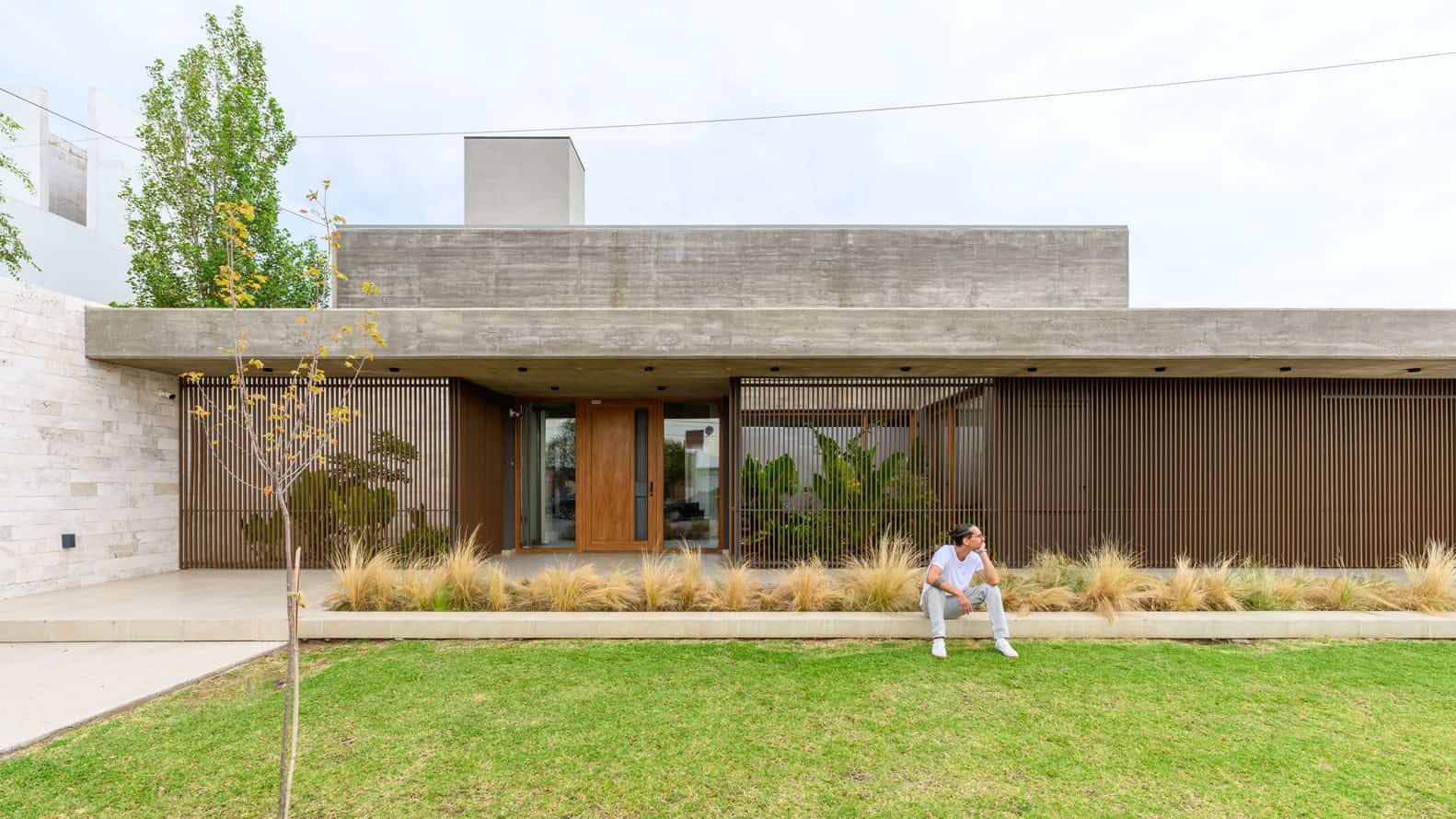 House G by Karlen + Clemente — front facade and entry bench, Río Tercero