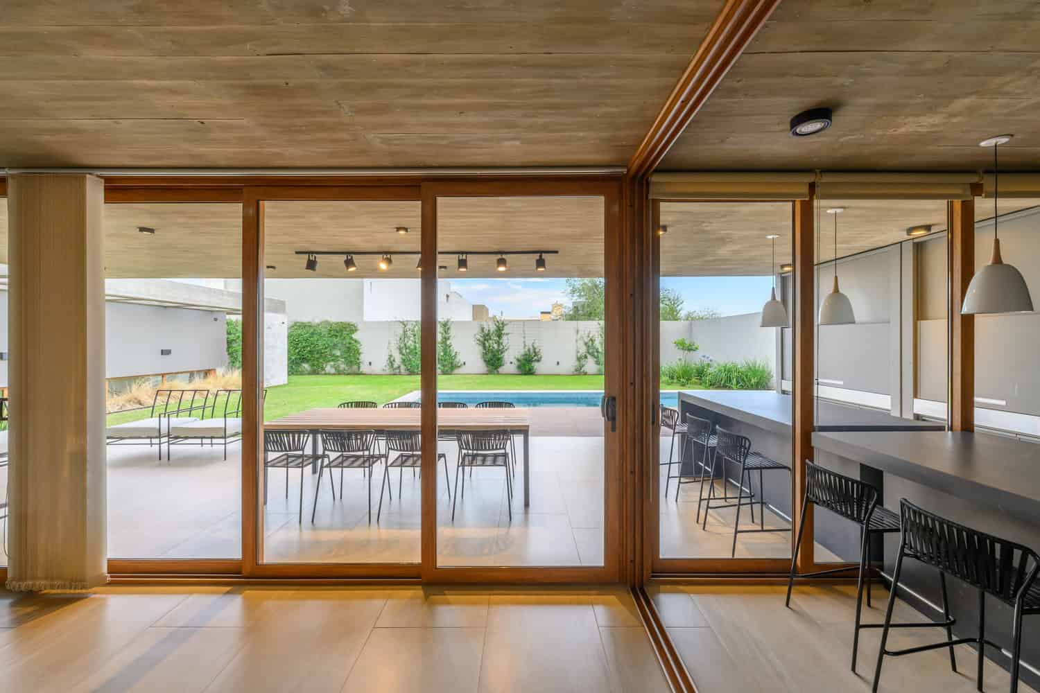 House G by Karlen + Clemente — full-height glass doors to patio and pool, Río Tercero
