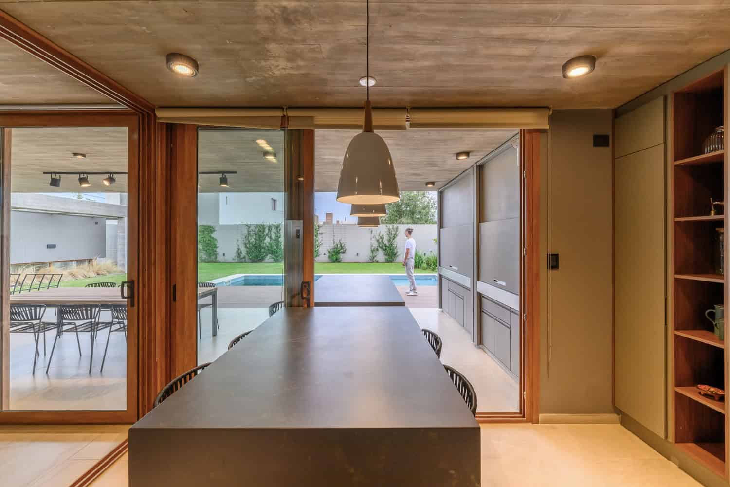 House G by Karlen + Clemente — kitchen island with patio and pool view, Río Tercero