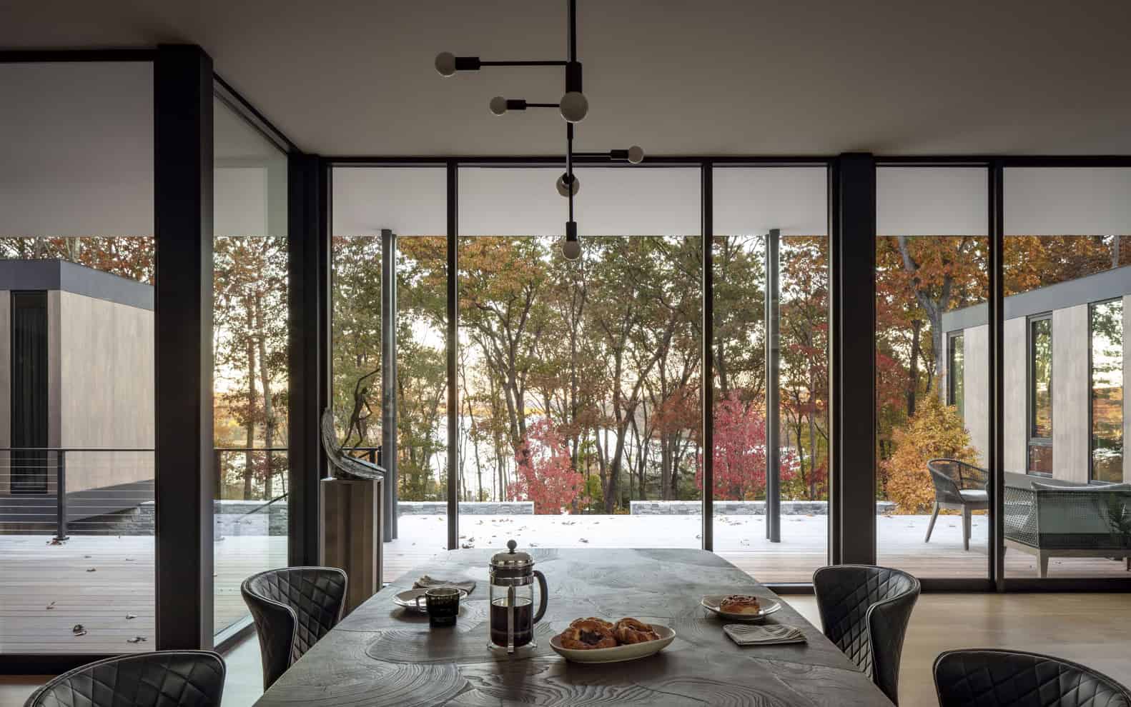 House in the Woods by Tom Lontine Architect, dining room with full-height glazing to woodland landscape in Connecticut