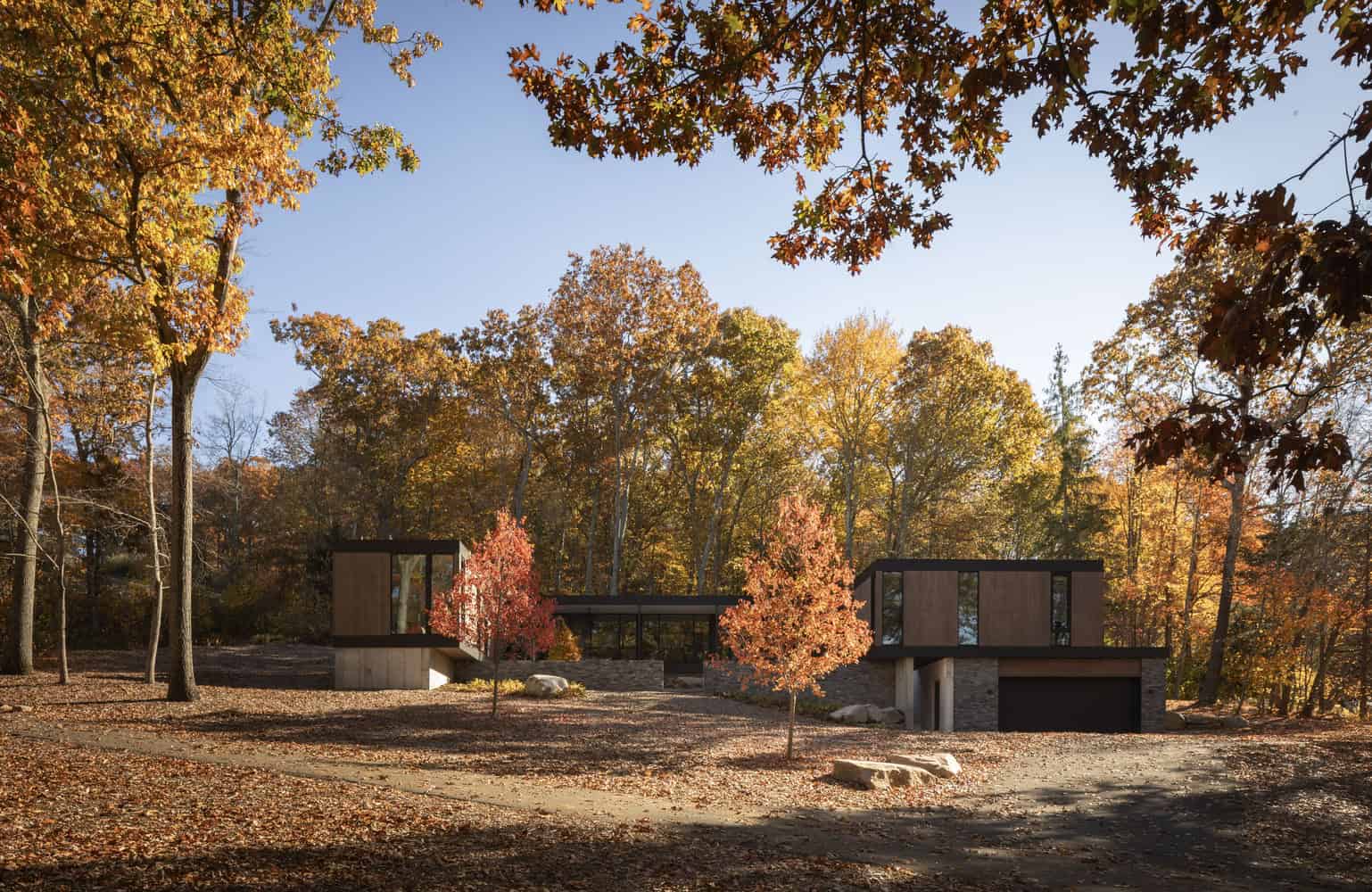 House in the Woods by Tom Lontine Architect, front elevation framed by autumn trees in Connecticut