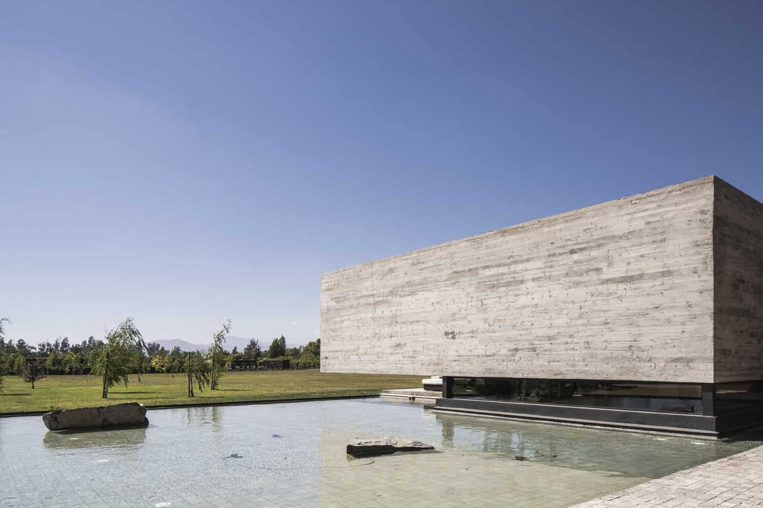 House La Primavera by Nicolas Vicente – reflecting pond and concrete volume, Chile