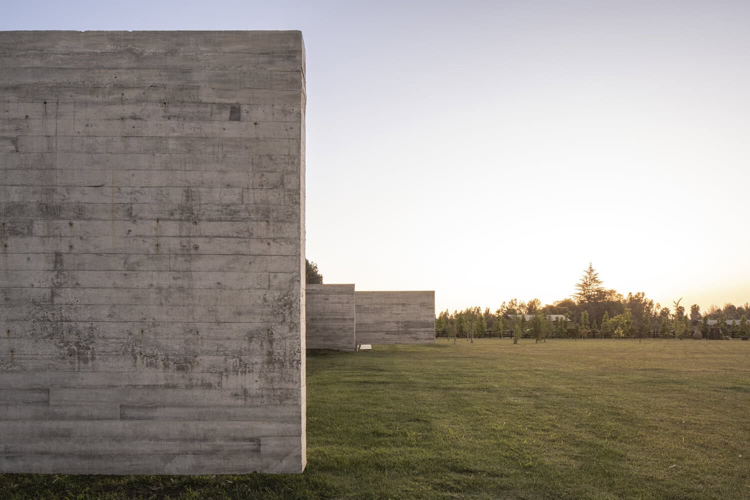 House La Primavera by Nicolas Vicente – minimalist concrete walls at sunset, Chile