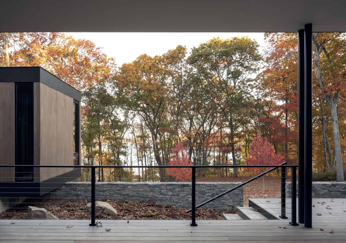 House in the Woods terrace with stone wall and forest backdrop in Connecticut by Tom Lontine Architect