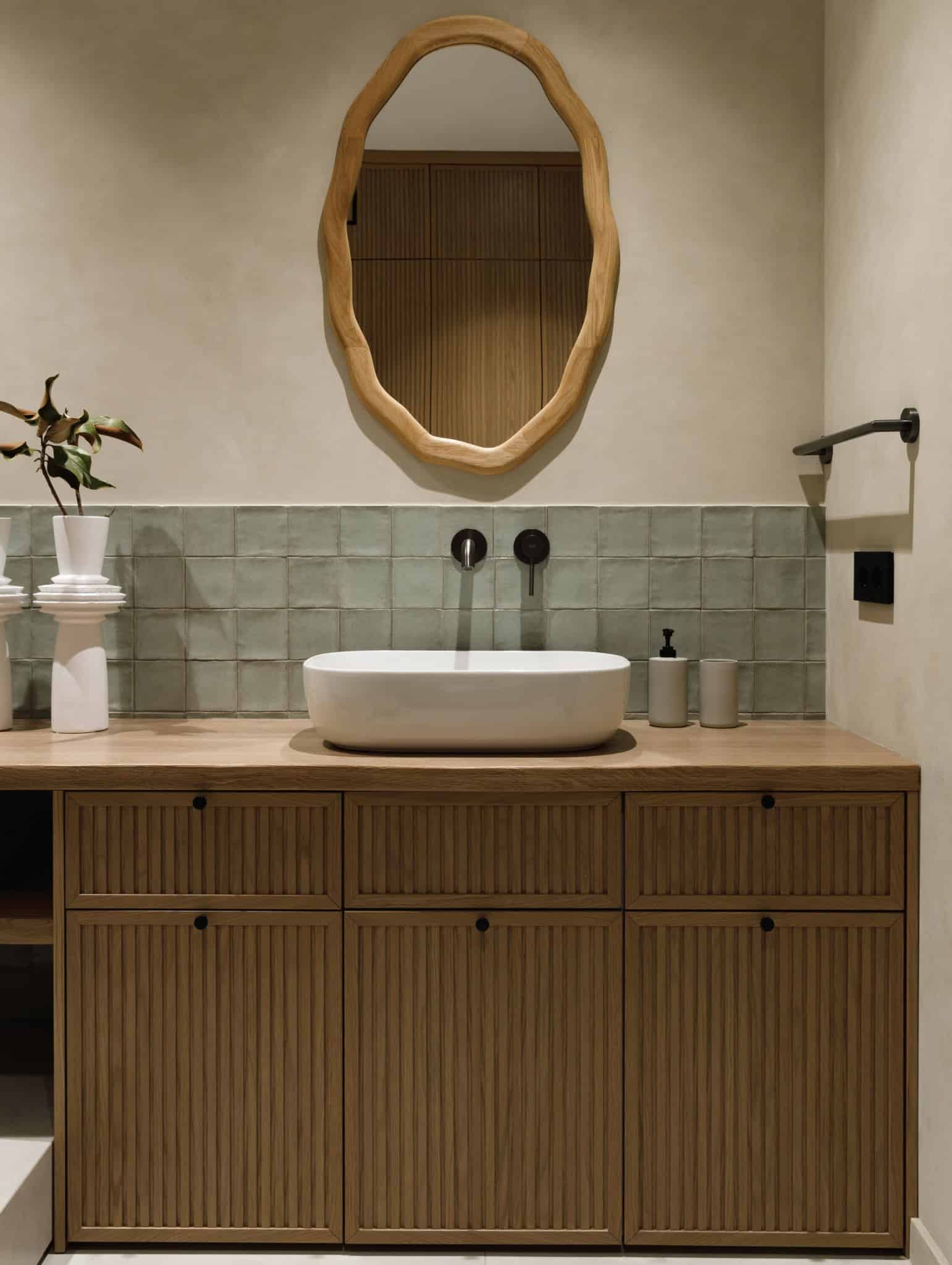 Wood vanity with vessel sink and organic wood mirror in Lesoparkovy Apartment bathroom by STARIKOVA.ARCHITECTS