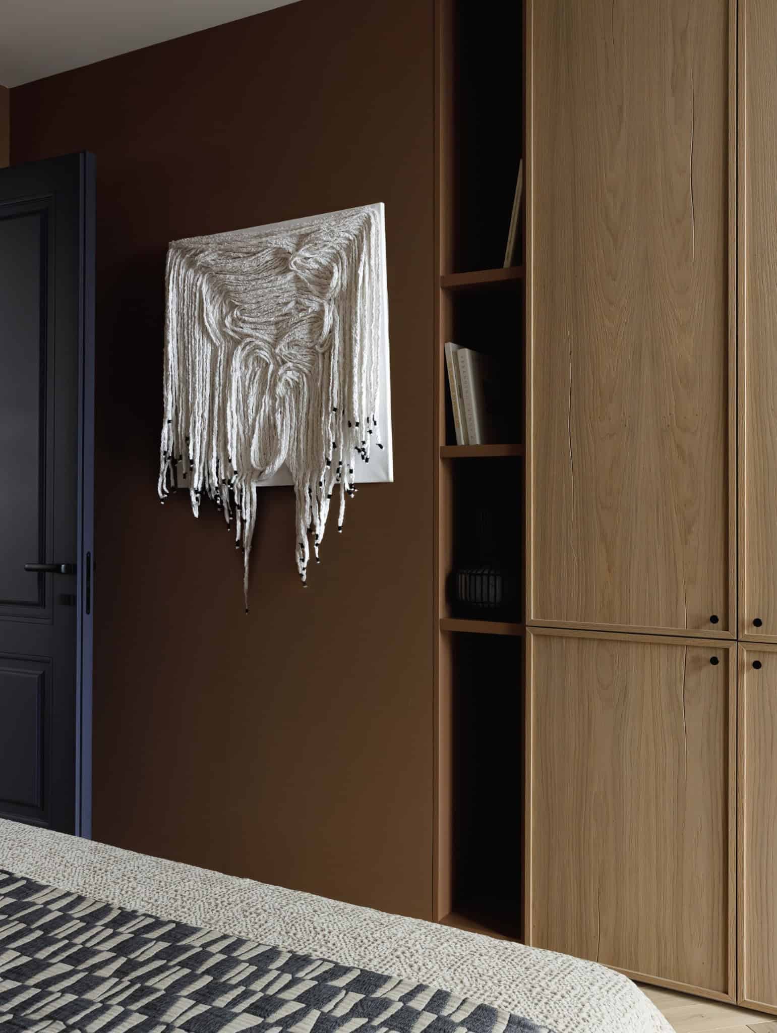 Textile wall art and wood cabinetry in Lesoparkovy Apartment bedroom by STARIKOVA.ARCHITECTS
