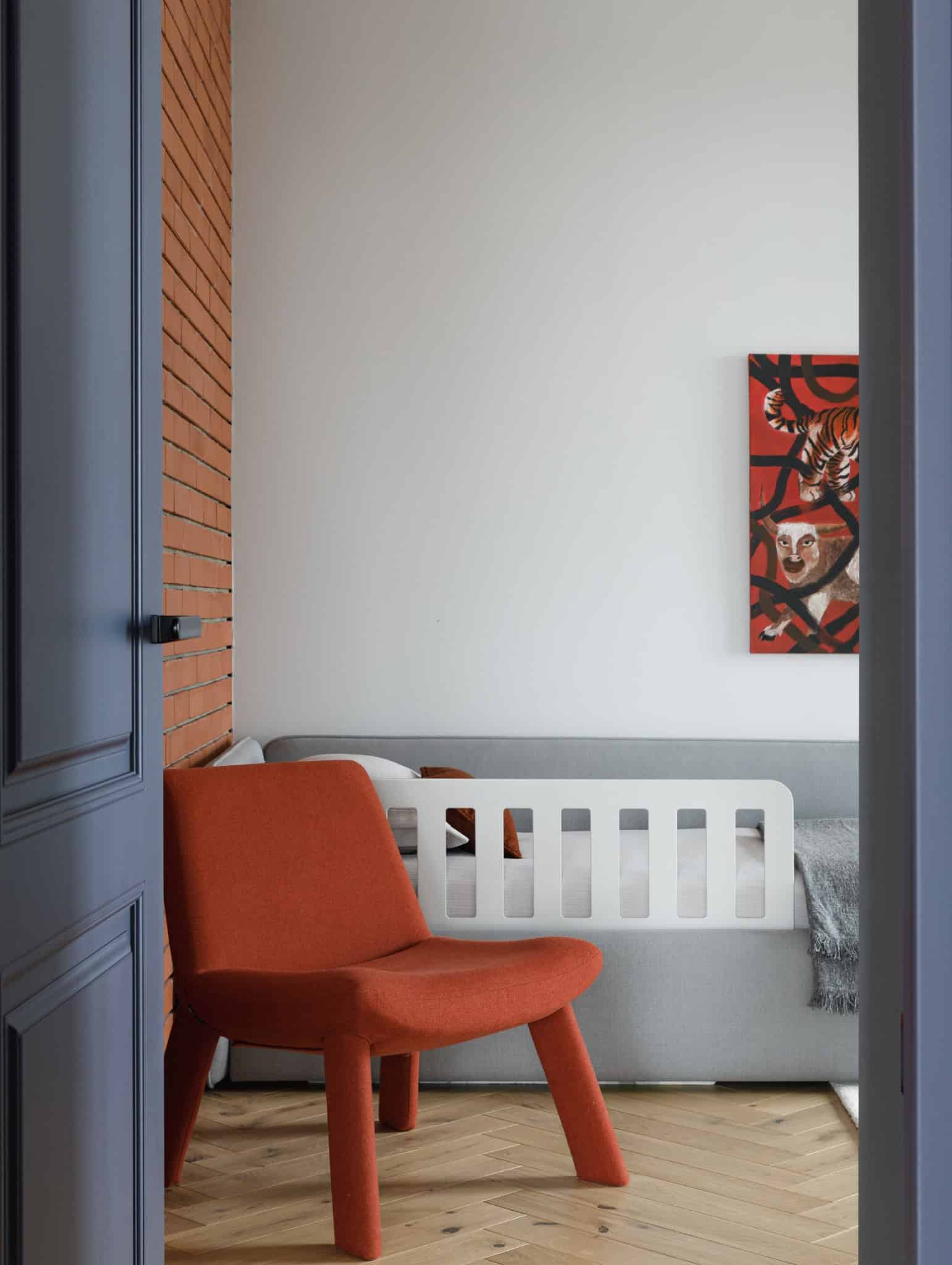 Lesoparkovy Apartment by STARIKOVA.ARCHITECTS kids room with orange chair and brick wall in Chelyabinsk, Russia