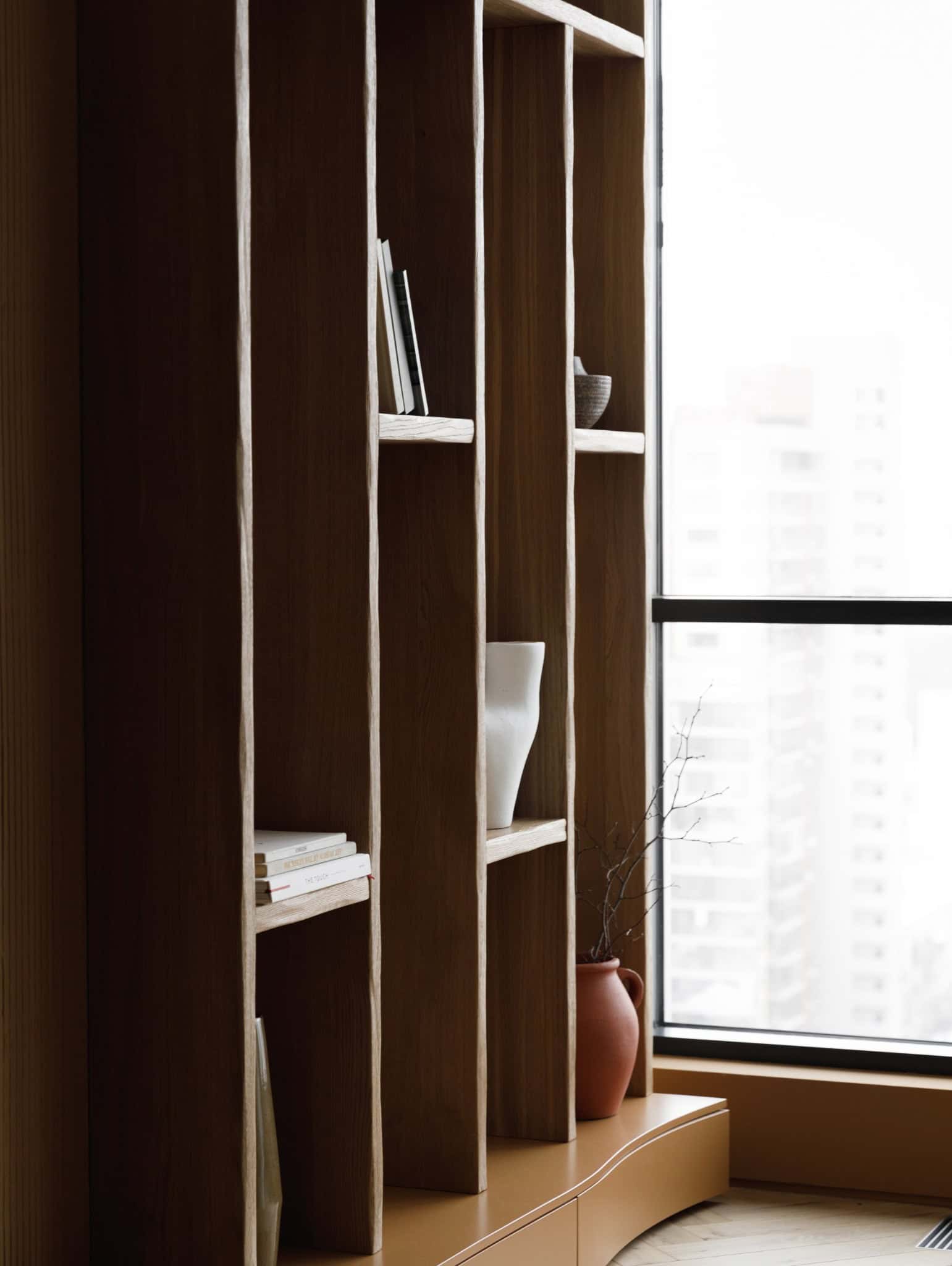 Living room shelves by large window in Lesoparkovy Apartment by STARIKOVA.ARCHITECTS in Chelyabinsk, Russia