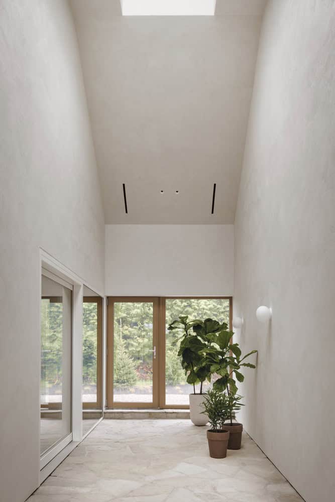 Maison Melba corridor by Atelier L’Abri with skylight and indoor garden in Frelighsburg Quebec