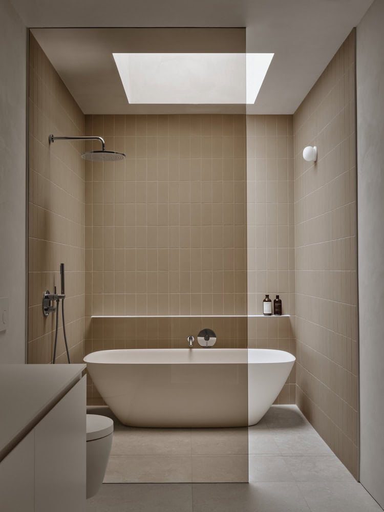 Maison Melba bathroom by Atelier L’Abri with freestanding tub, walk-in shower and skylight in Frelighsburg, Quebec
