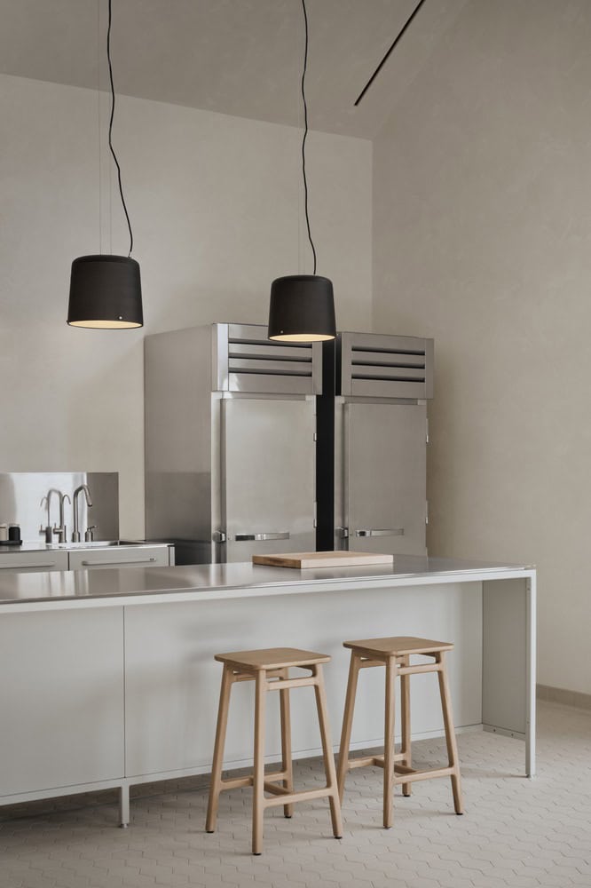 Maison Melba chef kitchen by Atelier L’Abri with stainless steel island and commercial appliances in Frelighsburg Quebec