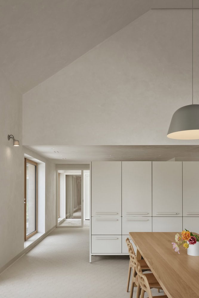 Maison Melba by Atelier L’Abri with corridor leading to kitchen storage and soft natural light in Frelighsburg Quebec