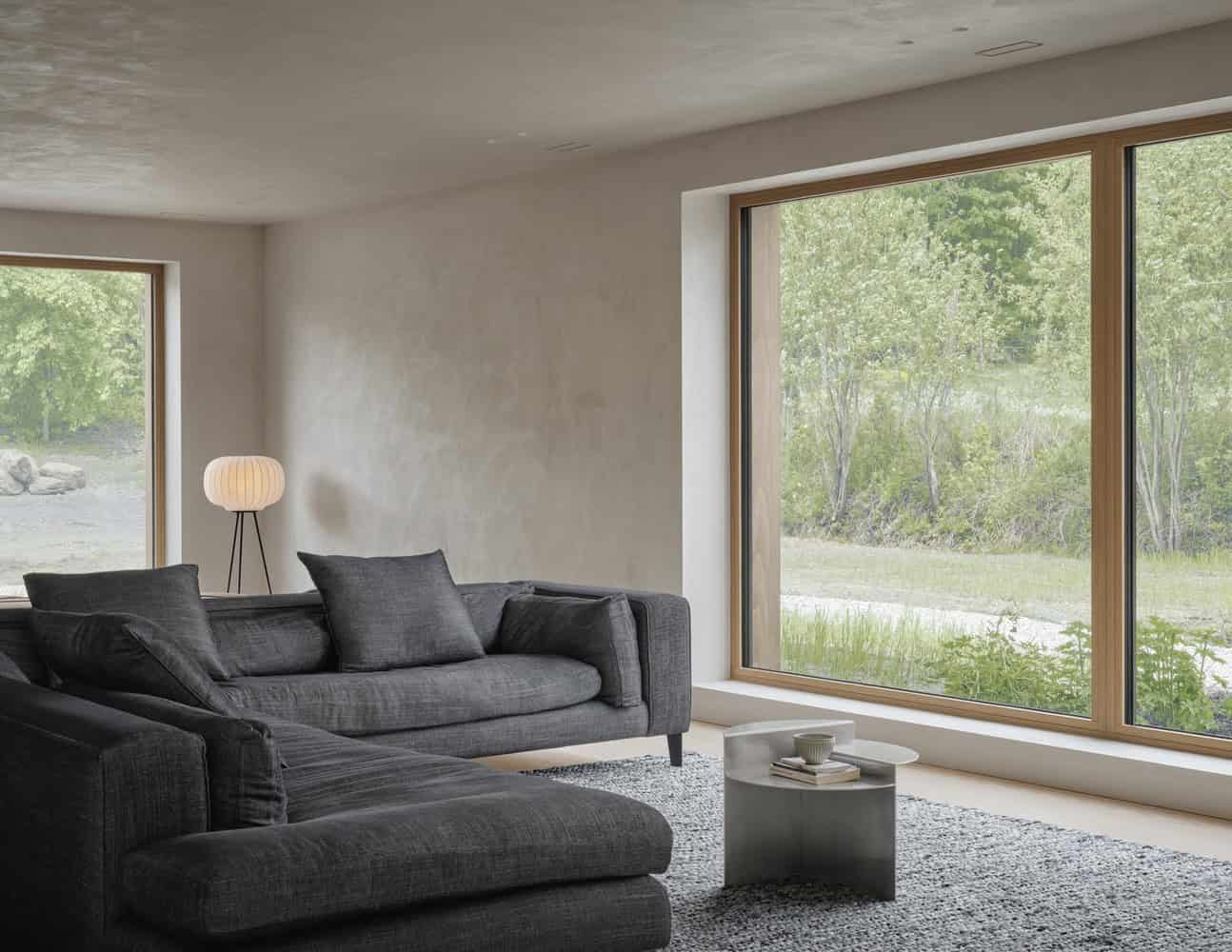 Maison Melba by Atelier L’Abri with large window seating area and sculptural floor lamp in Frelighsburg Quebec