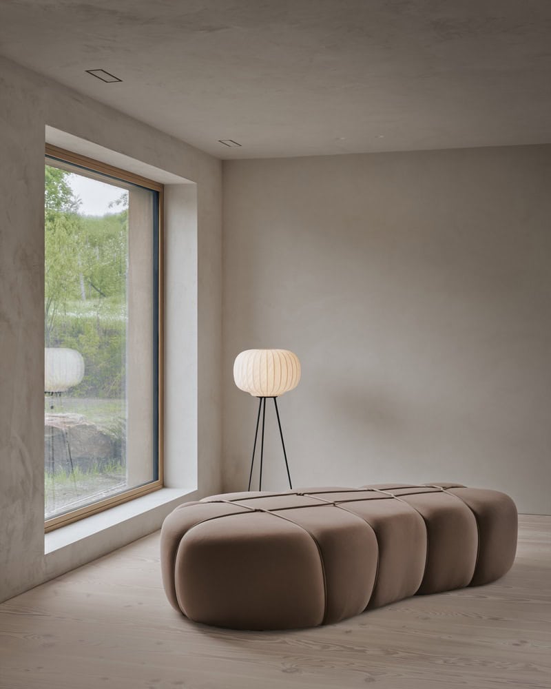 Maison Melba lounge area by Atelier L’Abri with sculptural bench, floor lamp and large window in Frelighsburg, Quebec