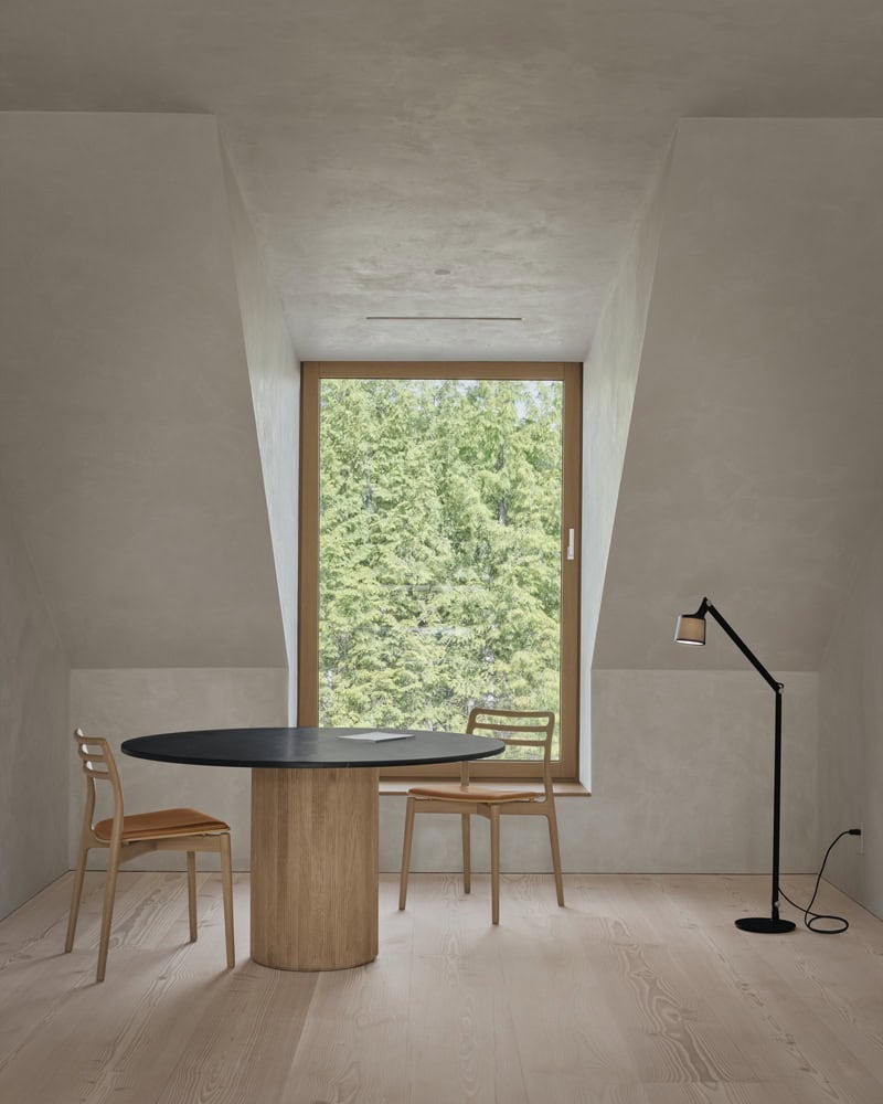 Maison Melba by Atelier L’Abri with round table nook, wooden chairs and large window in Frelighsburg Quebec