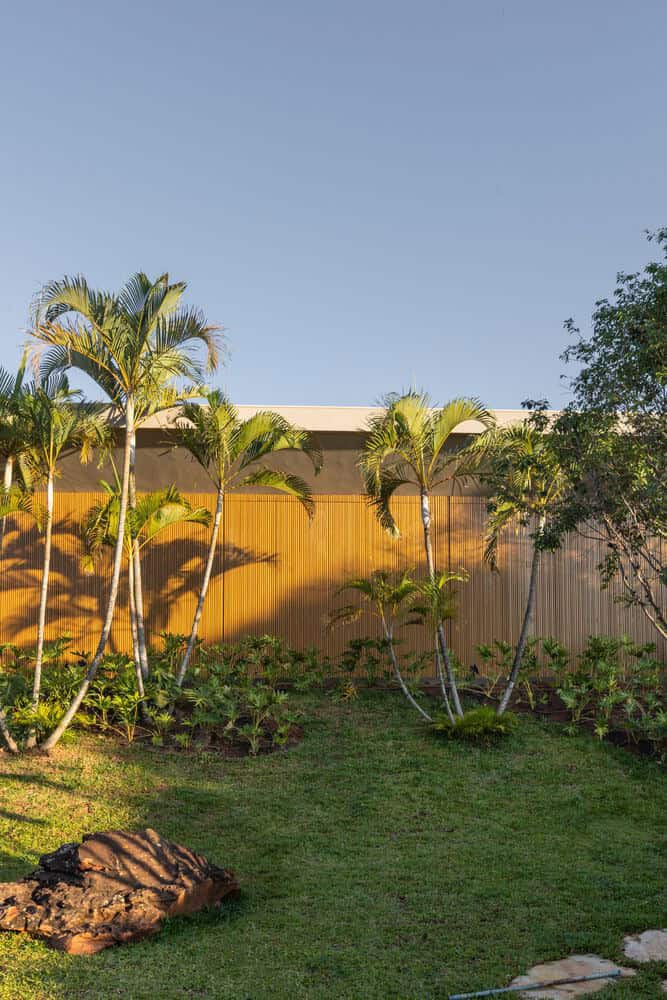 MCZ House Facade Palm Trees by NIU Arquitetura e Construção MCZ House by NIU Arquitetura e Construção, facade surrounded by palm trees and lush garden in Cristais Paulista, São Paulo, Brazil
