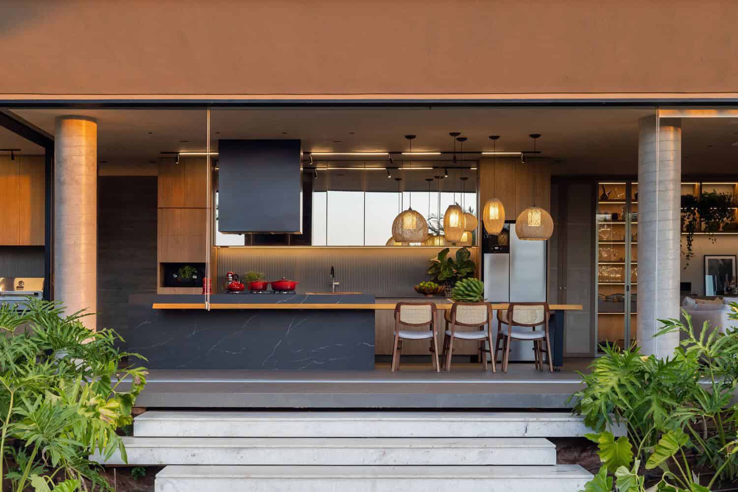 MCZ House Kitchen Dining Open Plan by NIU Arquitetura e Construção MCZ House by NIU Arquitetura e Construção, open-plan kitchen and dining area with rattan pendants in Cristais Paulista, São Paulo, Brazil