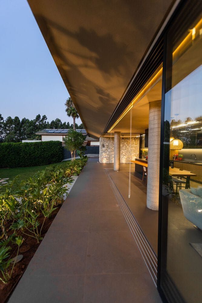 MCZ House Veranda Evening View by NIU Arquitetura e Construção MCZ House by NIU Arquitetura e Construção, veranda with evening lighting and garden view in Cristais Paulista, São Paulo, Brazil