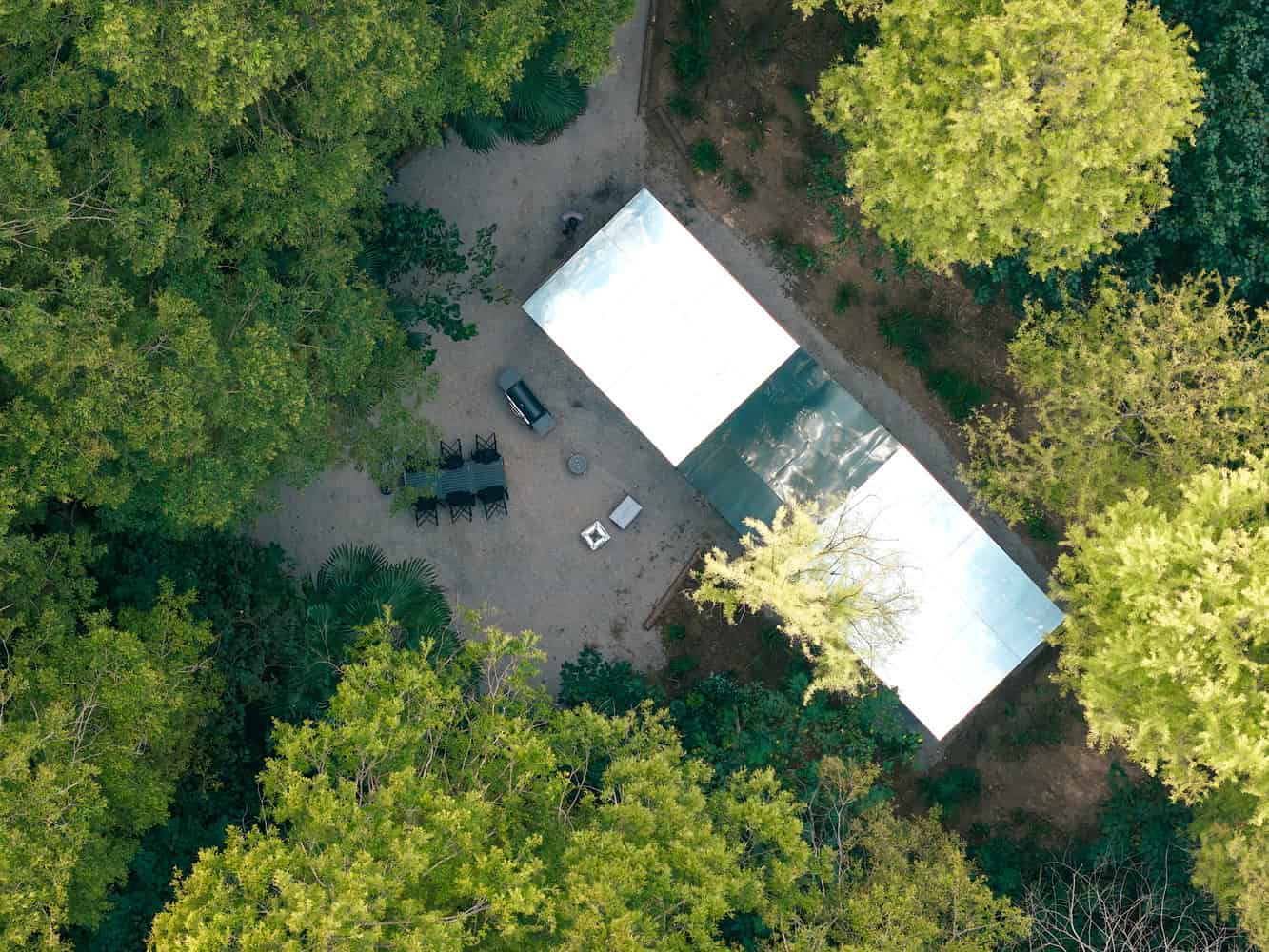 Merryda Wiki World-Secret Camp Aerial Top Roof Courtyard by Wiki World + Advanced Architecture Lab Top-down aerial view of Merryda Wiki World-Secret Camp by Wiki World + Advanced Architecture Lab with mirrored roofs and forest courtyard in China
