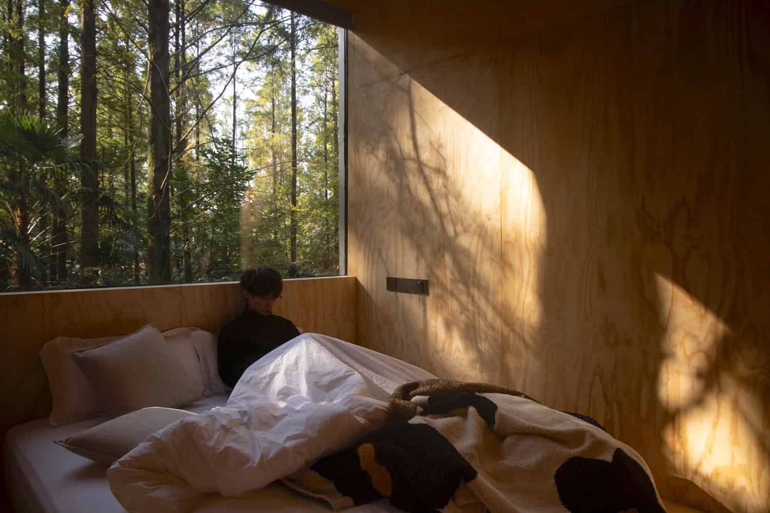 Merryda Wiki World-Secret Camp Bedroom Forest Window Interior by Wiki World + Advanced Architecture Lab Bedroom interior at Merryda Wiki World-Secret Camp by Wiki World + Advanced Architecture Lab with large window to the forest in China