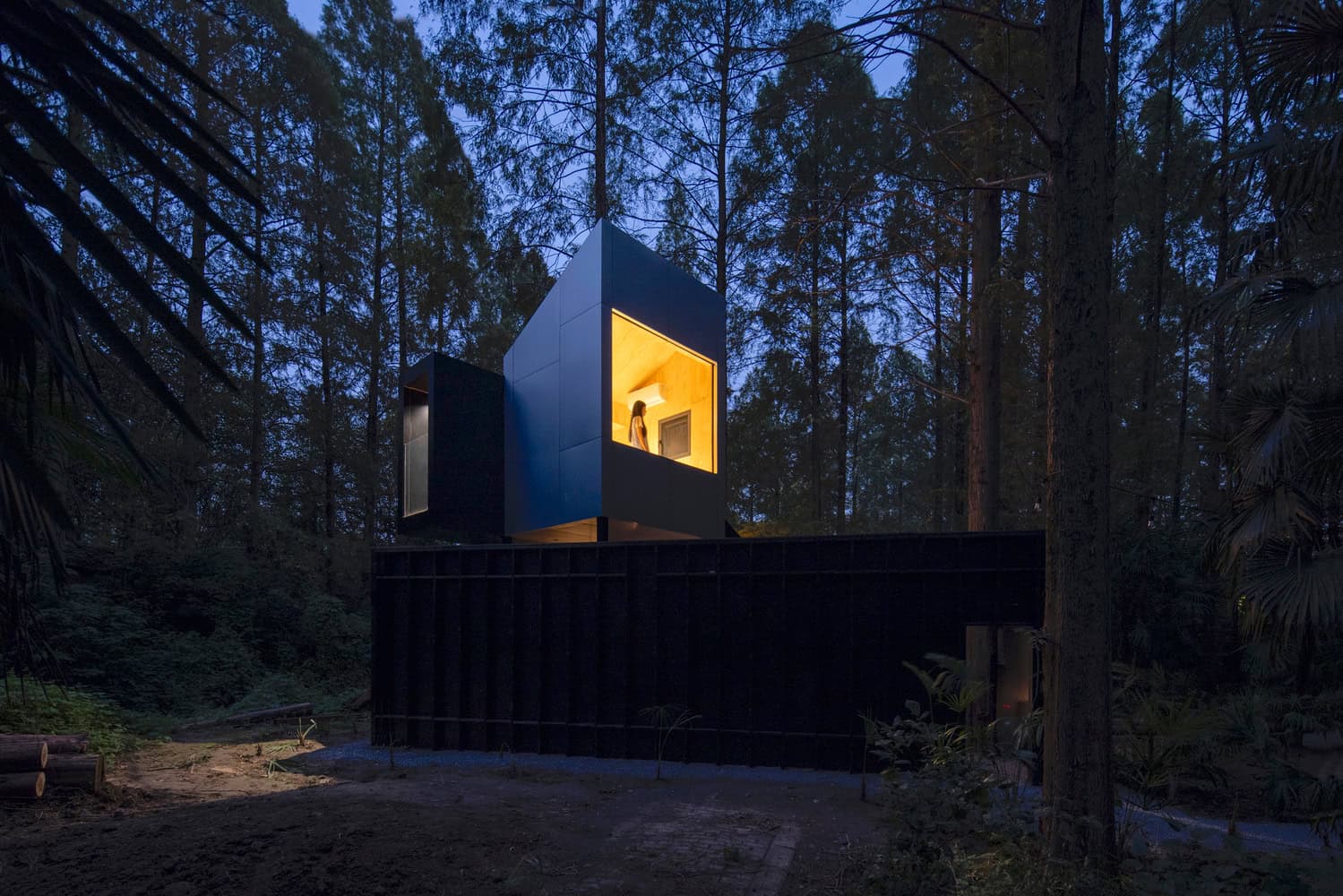 Merryda Wiki World-Secret Camp Black Cabin Night Elevation by Wiki World + Advanced Architecture Lab Black elevated cabin at Merryda Wiki World-Secret Camp by Wiki World + Advanced Architecture Lab, glowing at night in China