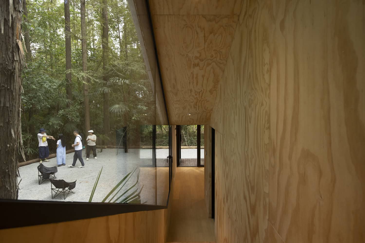 Merryda Wiki World-Secret Camp Interior Corridor Forest View by Wiki World + Advanced Architecture Lab Interior corridor of Merryda Wiki World-Secret Camp by Wiki World + Advanced Architecture Lab with timber walls and long window to the forest in China