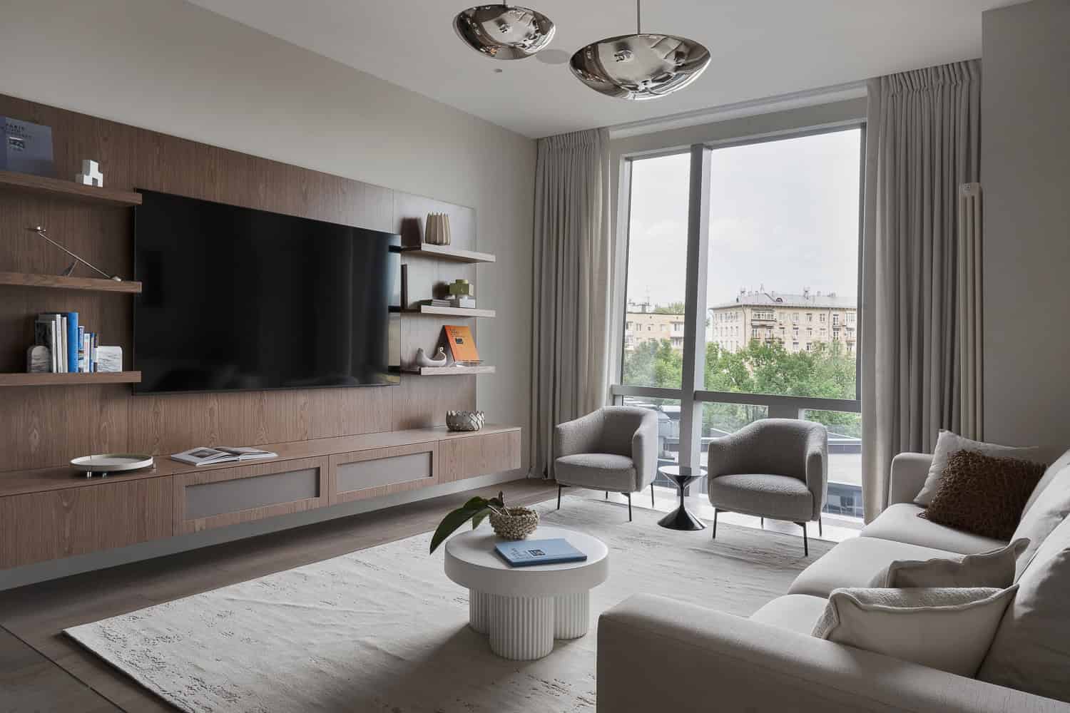 Contemporary living room interior with minimalist design, neutral color palette, modern furniture, and large windows showcasing an urban city view. Perfect for modern architecture and interior design inspiration.