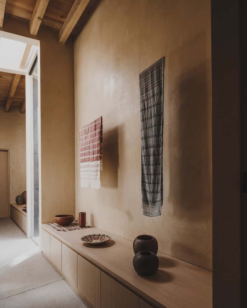 Ocote House by PPAA, gallery hallway with textiles and ceramics, Mexico