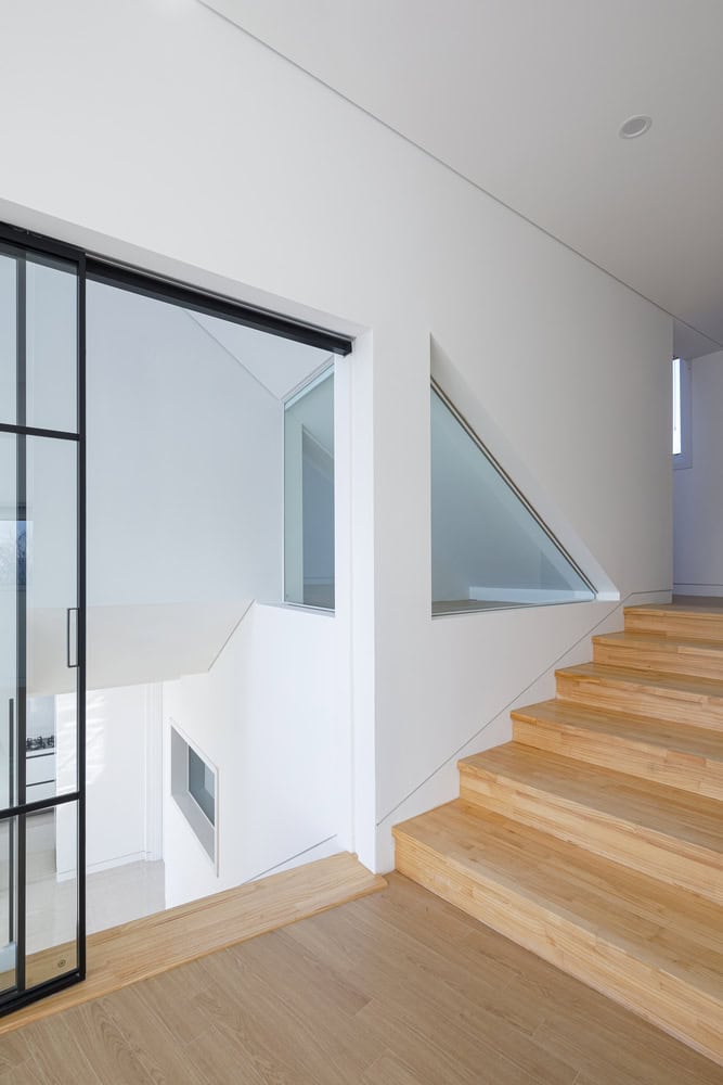 Pacific Residence by Moon Hoon split level stair landing with interior glazing in Seogwipo
