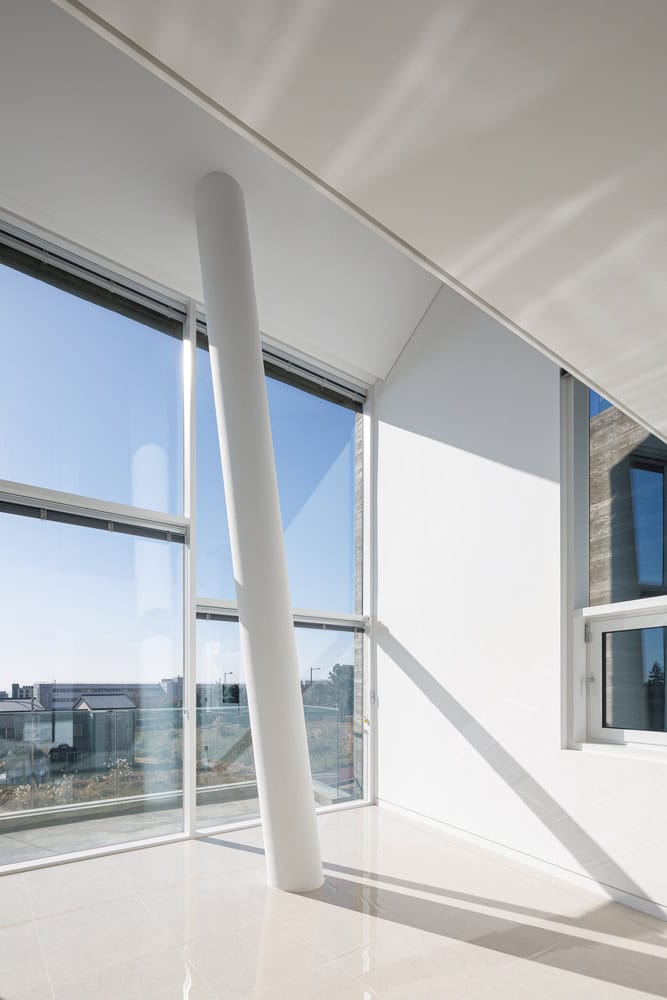 Pacific Residence by Moon Hoon tilted white column beside corner window in Seogwipo