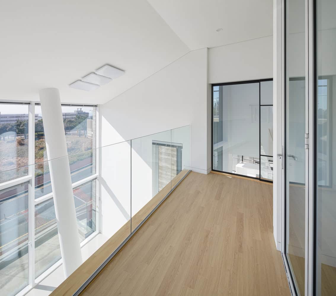 Bright modern interior balcony with glass railing, large windows, and minimalist design. Perfect for contemporary architecture and sleek home designs, showcasing innovative architectural elements.