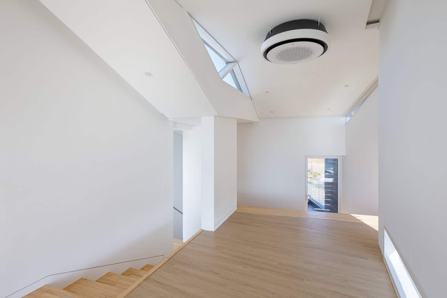 Pacific Residence by Moon Hoon upper level circulation hall with timber floor in Seogwipo