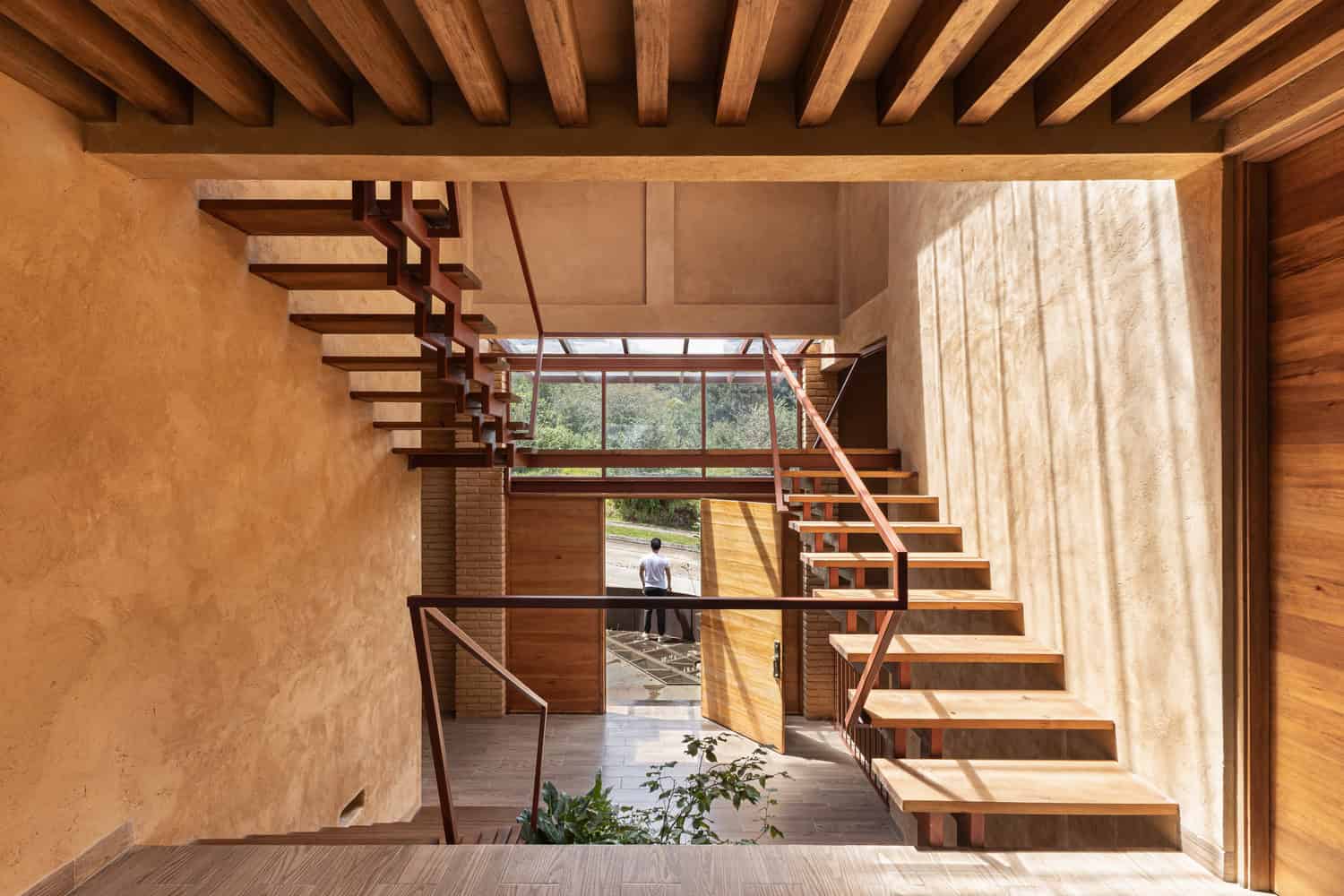Daylit atrium of The Sierra House by Valdez Arquitectos with floating staircases leading to the main entrance in Chiapas, Mexico