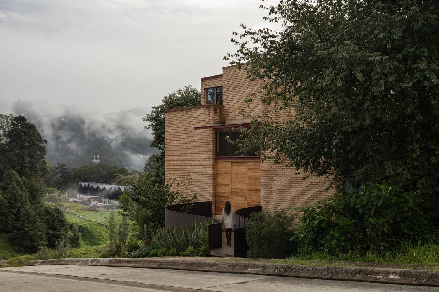 Entrance ramp of The Sierra House by Valdez Arquitectos with misty mountain landscape in Chiapas, Mexico