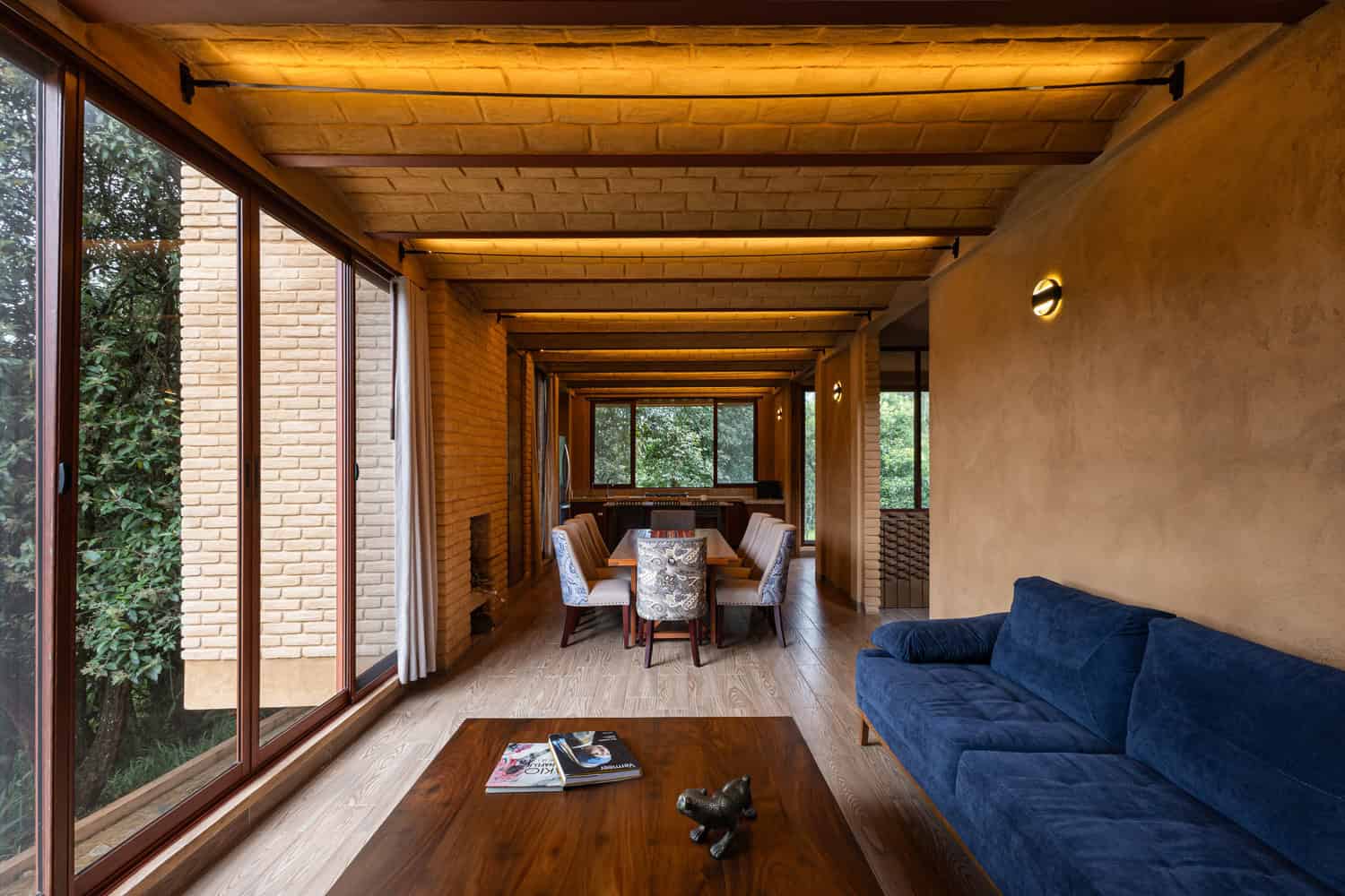 Open-plan living and dining space of The Sierra House by Valdez Arquitectos with large windows to the forest in Chiapas, Mexico