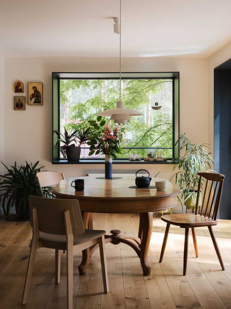 Dining room at Skubianka House by SZCZ Jakub Szczesny with large forest-facing window in Skubianka