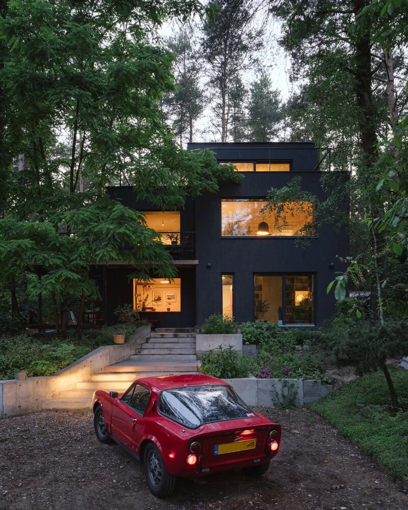 Front facade of Skubianka House by SZCZ Jakub Szczesny with driveway and red car in Skubianka